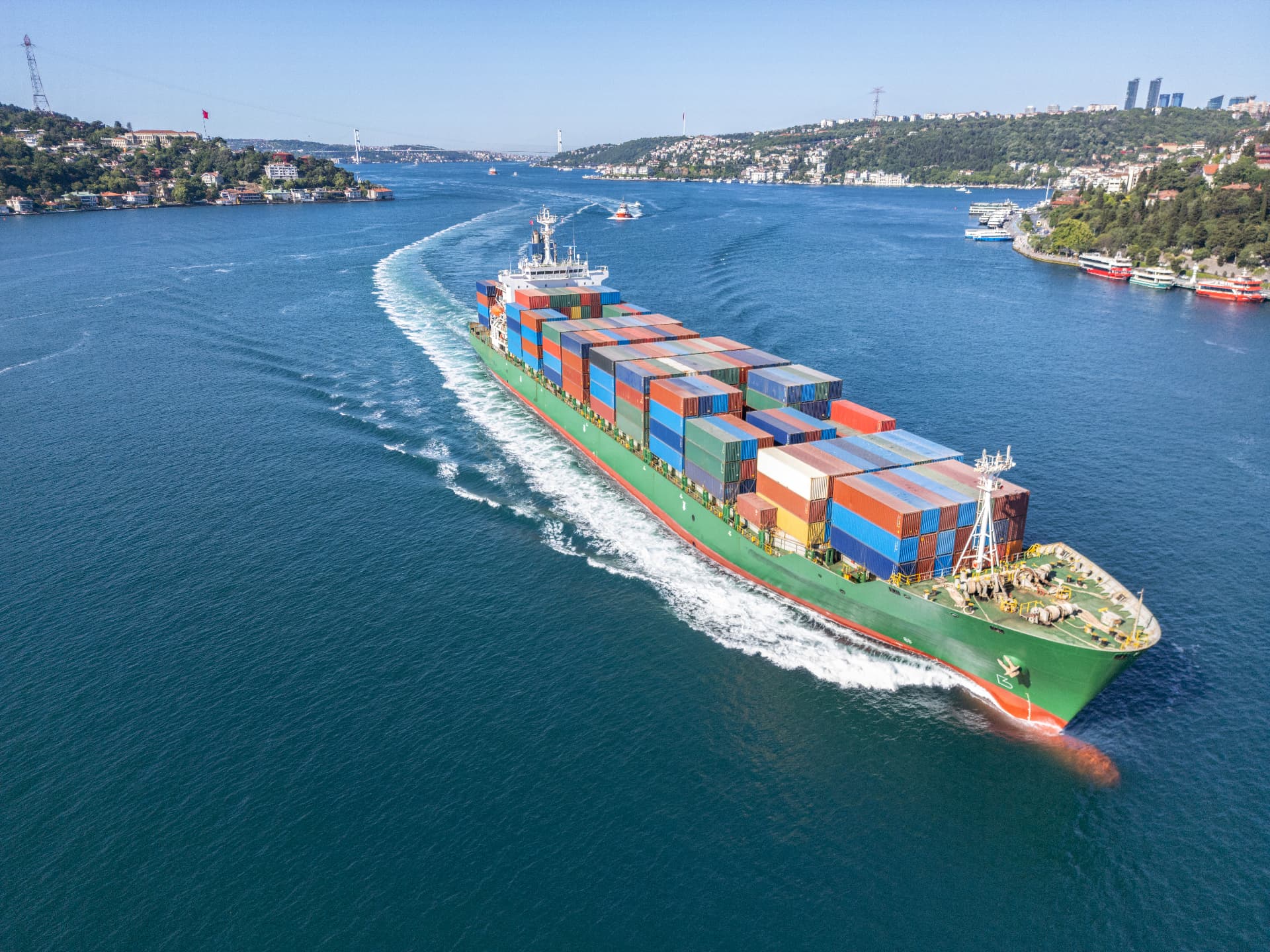 A container ship transits the Bosphorus, with the Istanbul skyline and bridges beyond